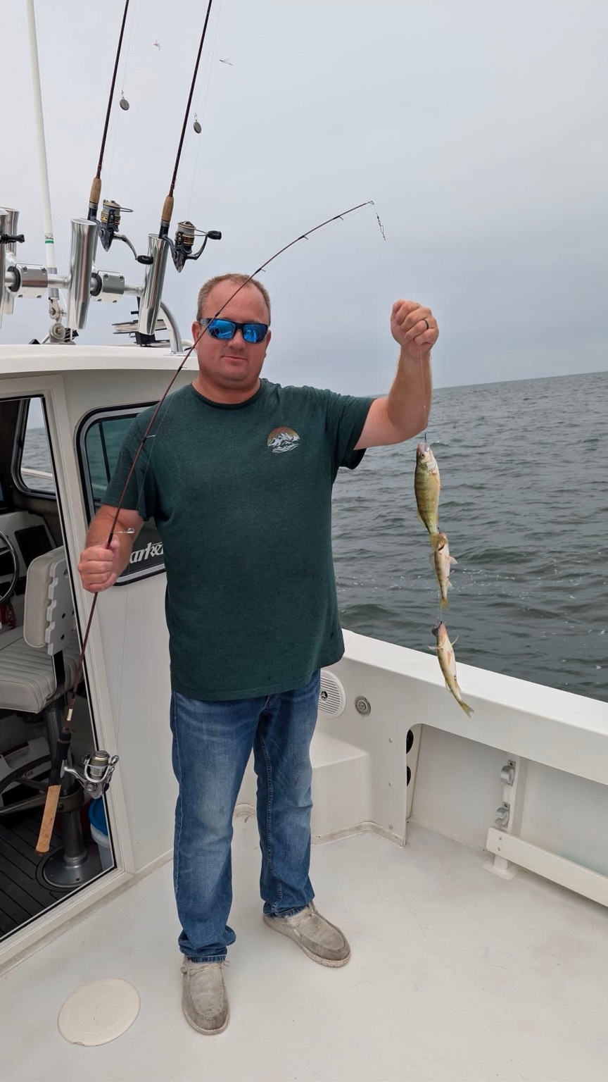 Captain Dan Lemon holding three yellow perch aboard Reel Therapy Sportfishing