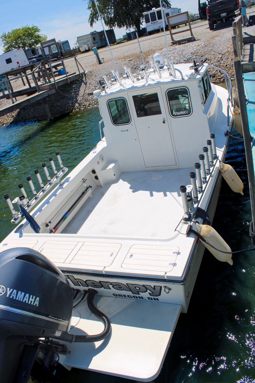 Open fishing cockpit with rod holders looking toward the pilothouse